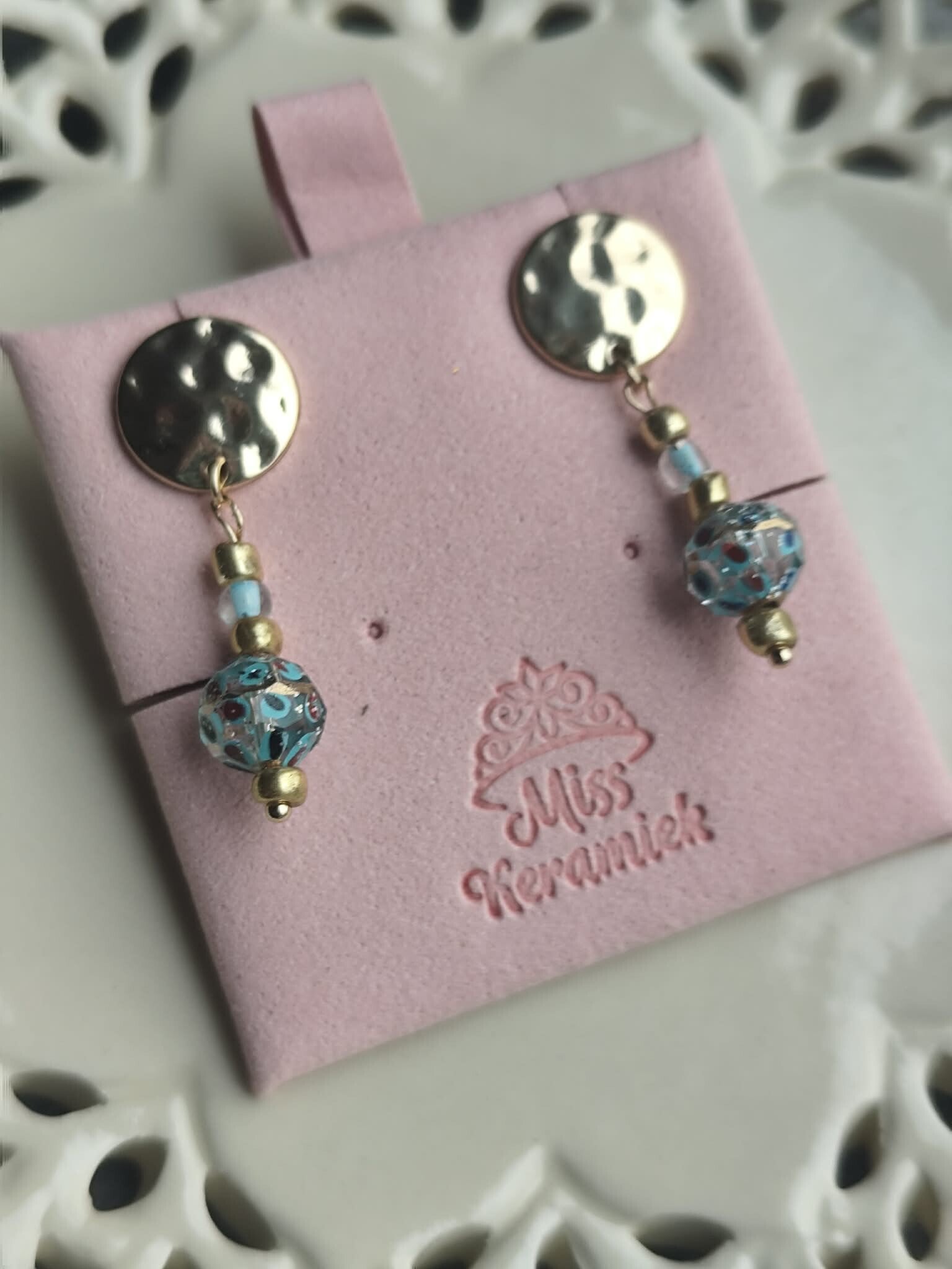 Gouden knop met turqoise parel