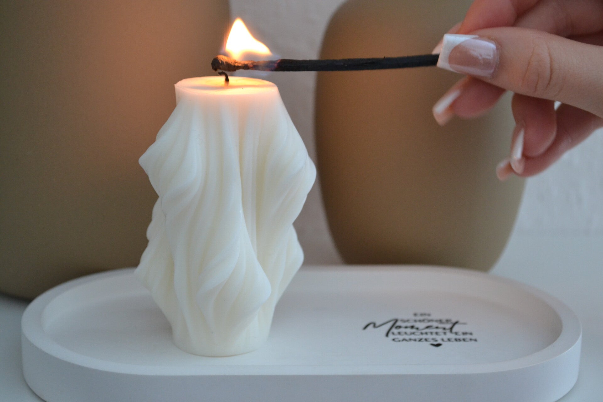 Skulpturkerze die mit einem Streichholz angezündet wird