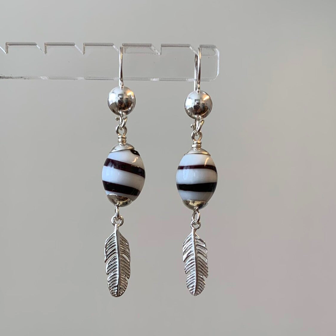 R2 - Zilveren oorbellen met kromanti kralen met veertje