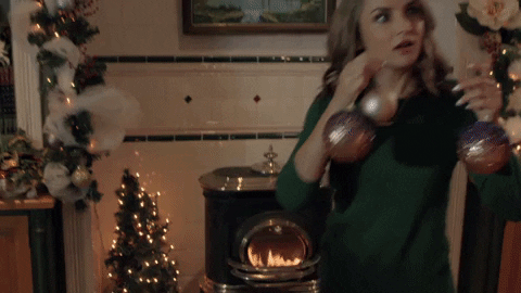 ✨ Couple decorating a Christmas tree with ornaments and lights.