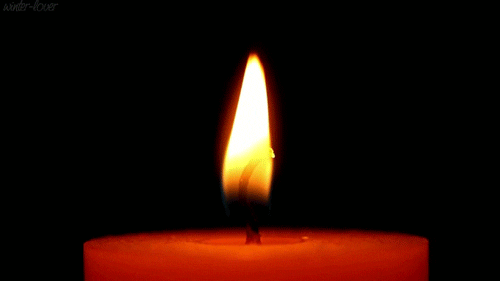 A single candle flame flickering warmly in the dark, creating a peaceful, comforting glow.