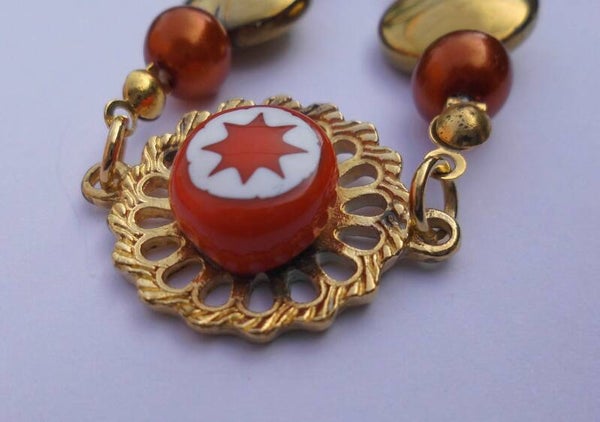 Goudkleurige armband met oranje en wit 55615x