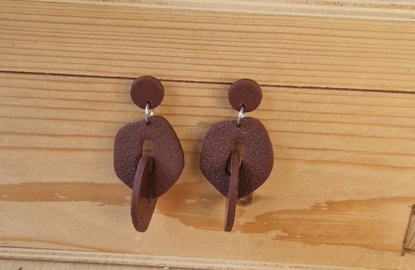 Bruine statement oorbellen.