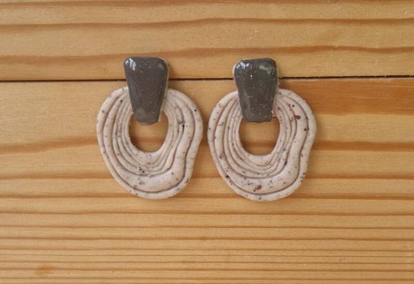 Oorbellen in creme grijs gemeleerd.