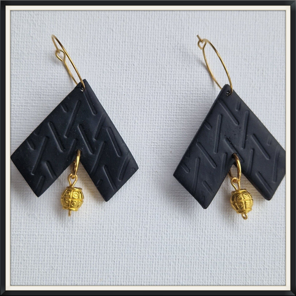 Zwarte oorbellen aan ring .