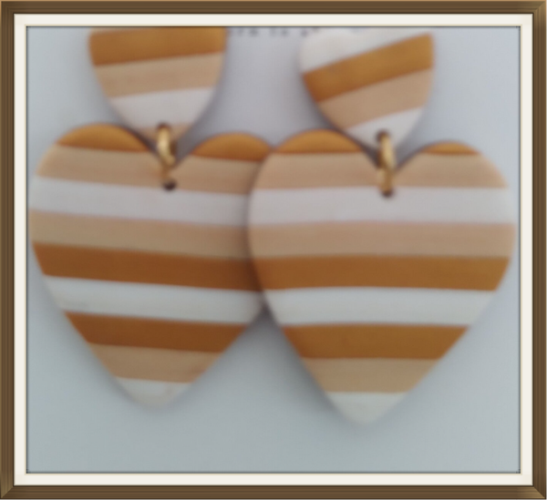 Goud gestreepte harten oorbellen.