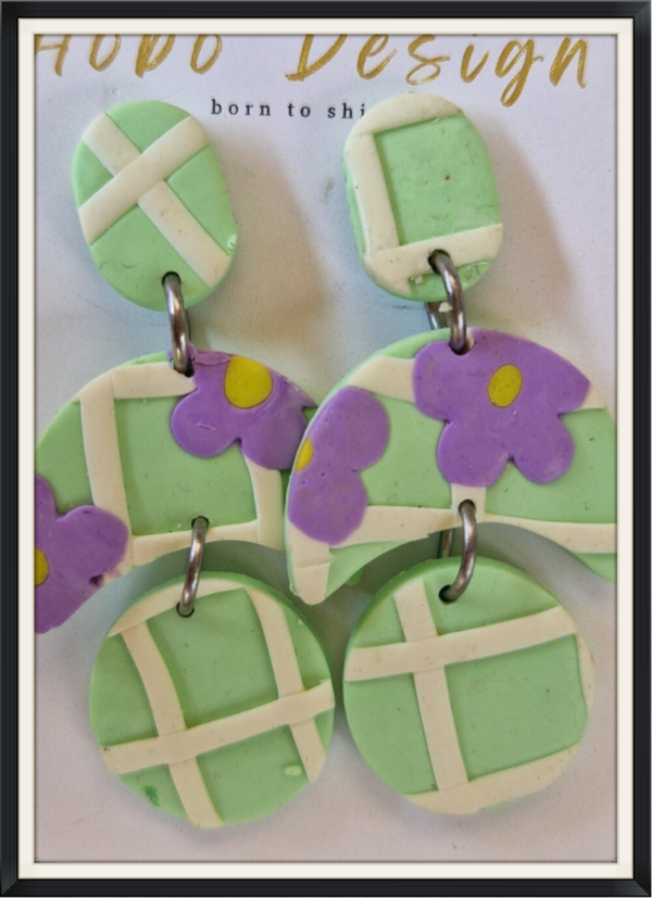 Oorhanger in licht groen met lila bloem.