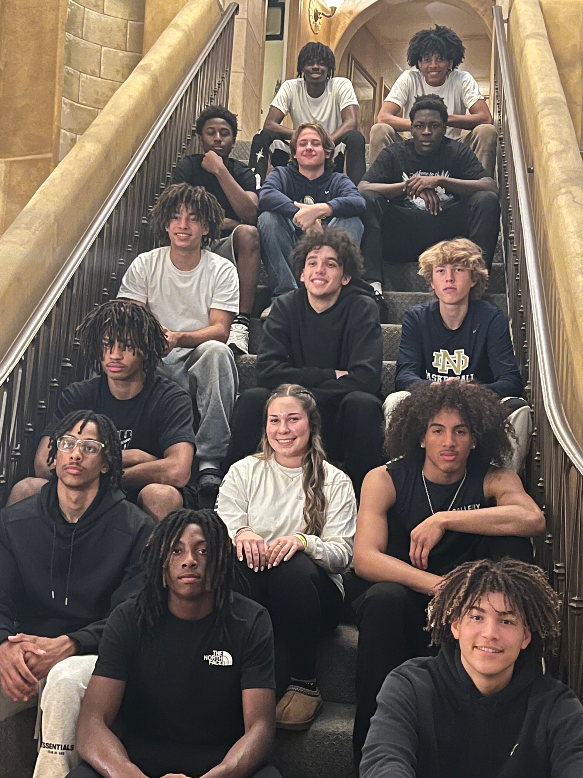 Smiling on the staircase with the boys varsity basketball team in the team house. 