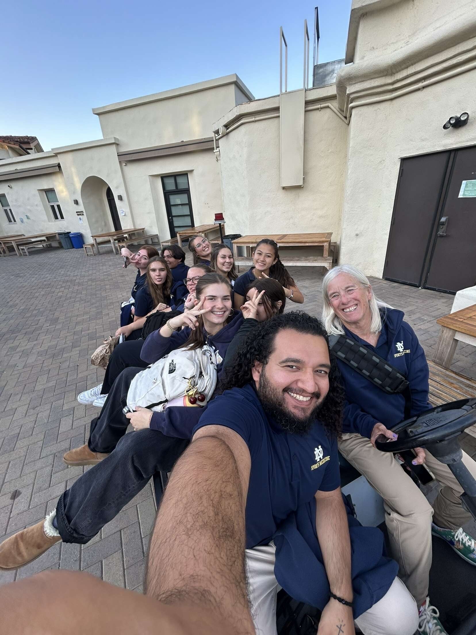 Students and trainers on the golf cart posing for a .5 picture. 