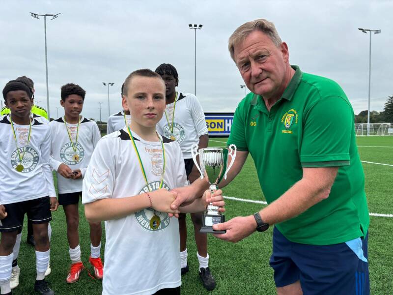 Martin Ward is presented with the U14 Premier League Trophy by Gerry Gallagher