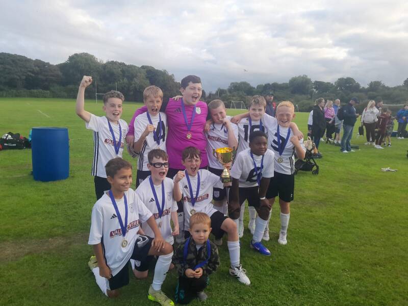 U12 Athletic team photo celebrating their shield win at the Kenny Woods Memorial Tournament in Bushmills on 15th August 2026