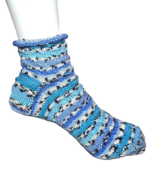 Socke in Blautönen und dezenten Zopfmuster am Bund
