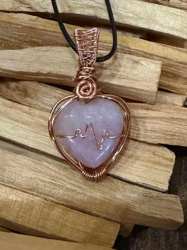 Rose quartz wrapped in copper with a heart rhythm design.