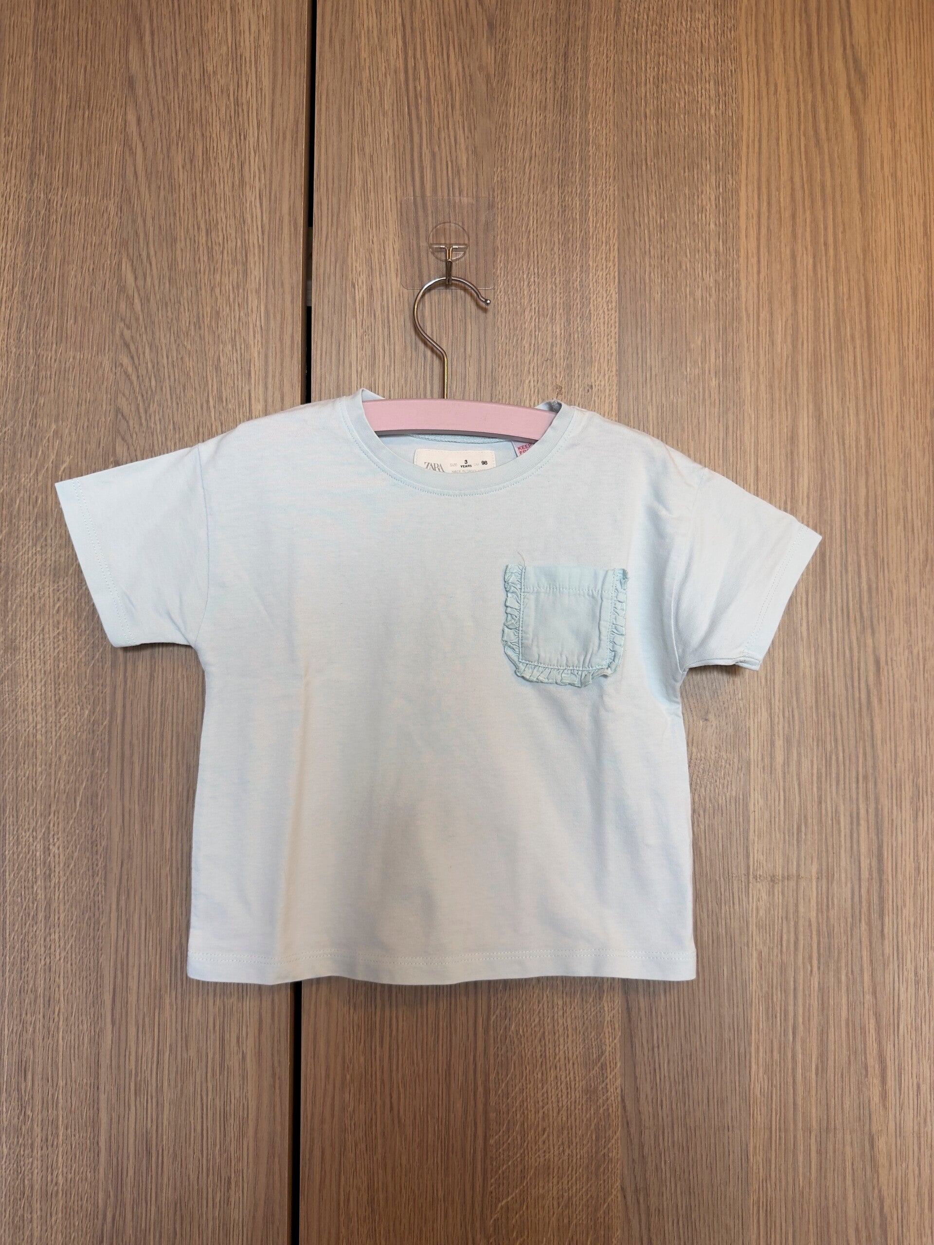 zara - lichtblauw shirt met ruffle zakje - maat 98