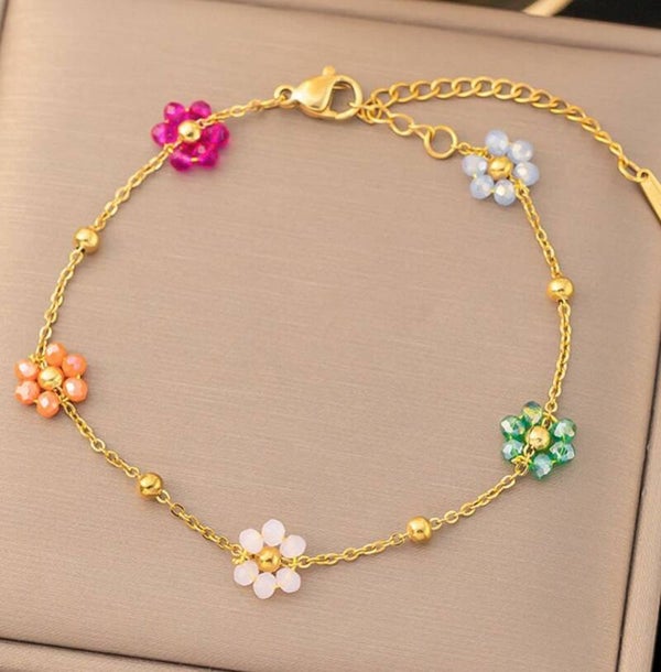 Pulsera Dorada con dijes de flores de colores $20
