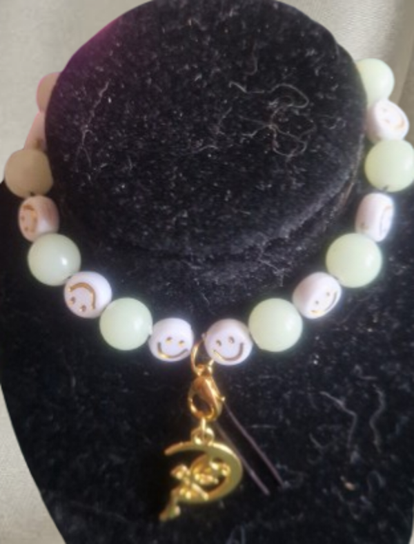 Bracelet perles rondes phosphorescente vertes et perles blanches motif smiley doré, cordon élastique, pendentif lune et fée doré