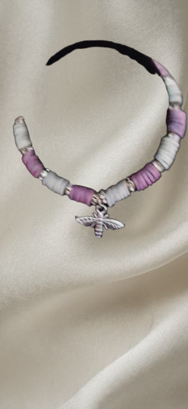 Bracelet en perles plates blanches et rose foncé, perles intercalaire doré avec strass, cordon élastique noir, pendentif papillon argenté