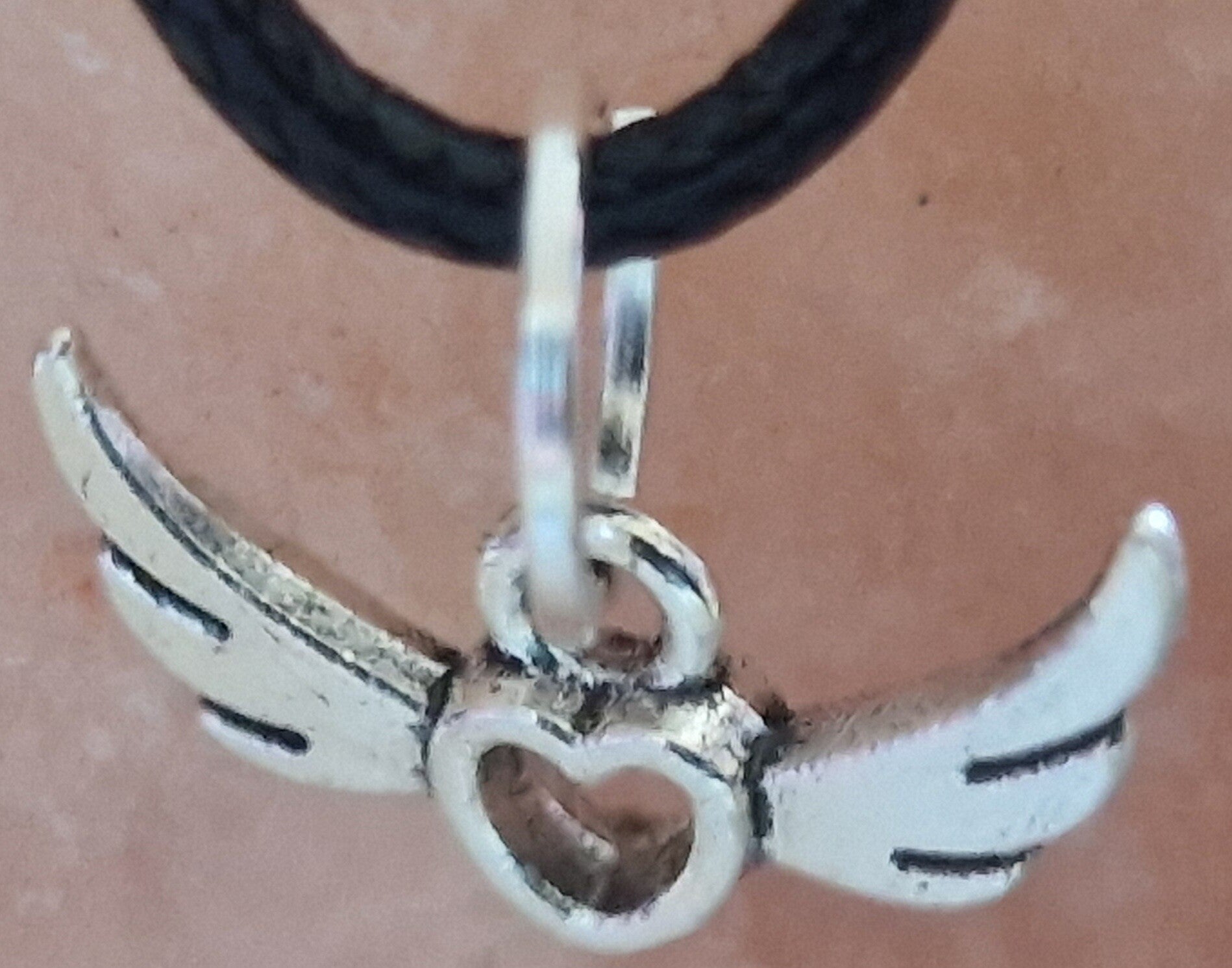 Collier avec pendentif ailes argenté cordon ciré cuir noir avec boucles