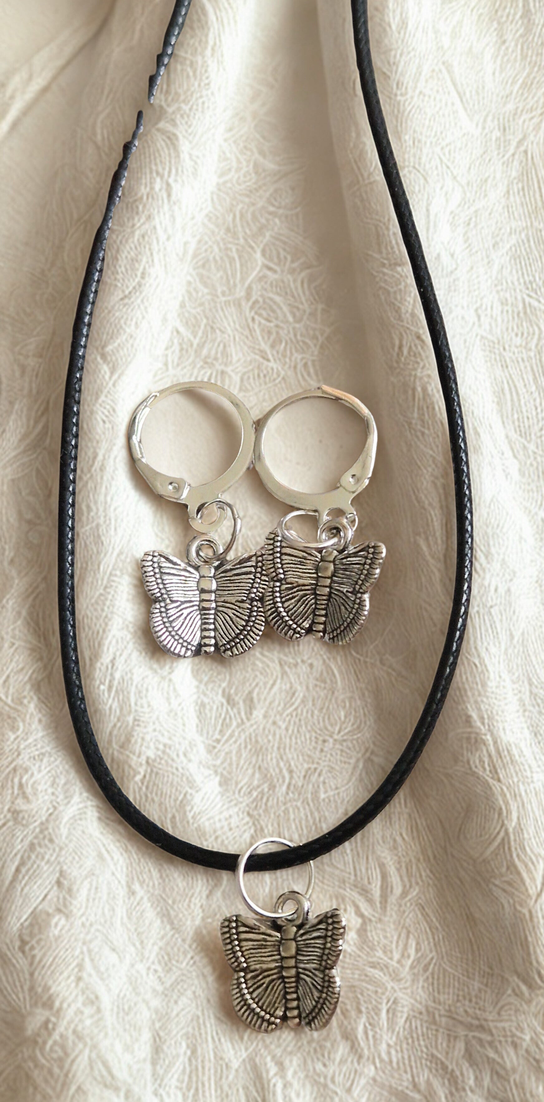 Parure  Collier avec pendentif papillon argenté cordon ciré cuir noir avec boucles argenté et boucles d'oreilles papillon argenté