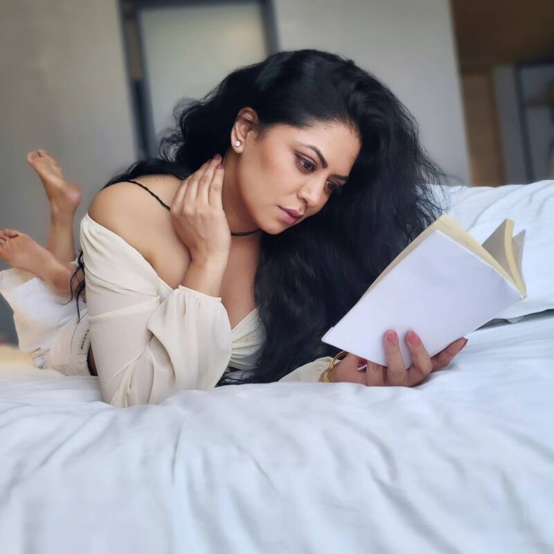 Kavita Kaushik read book on a bed