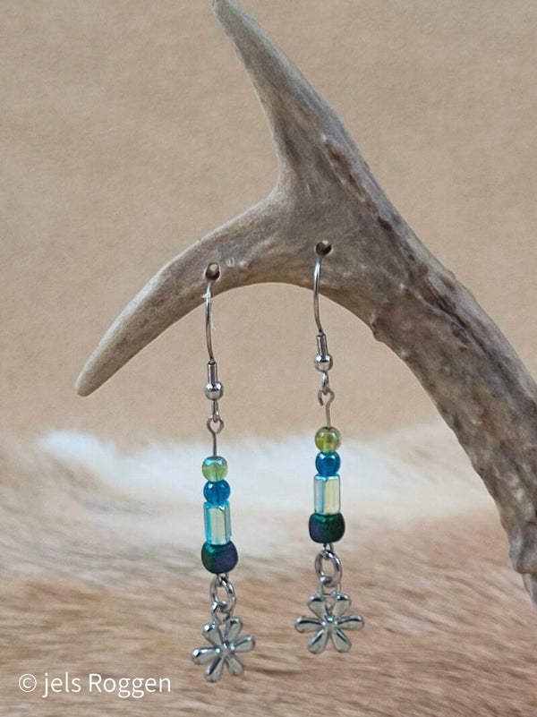 Groen/blauwe glaskralen met zilverkleurige bloemetjes