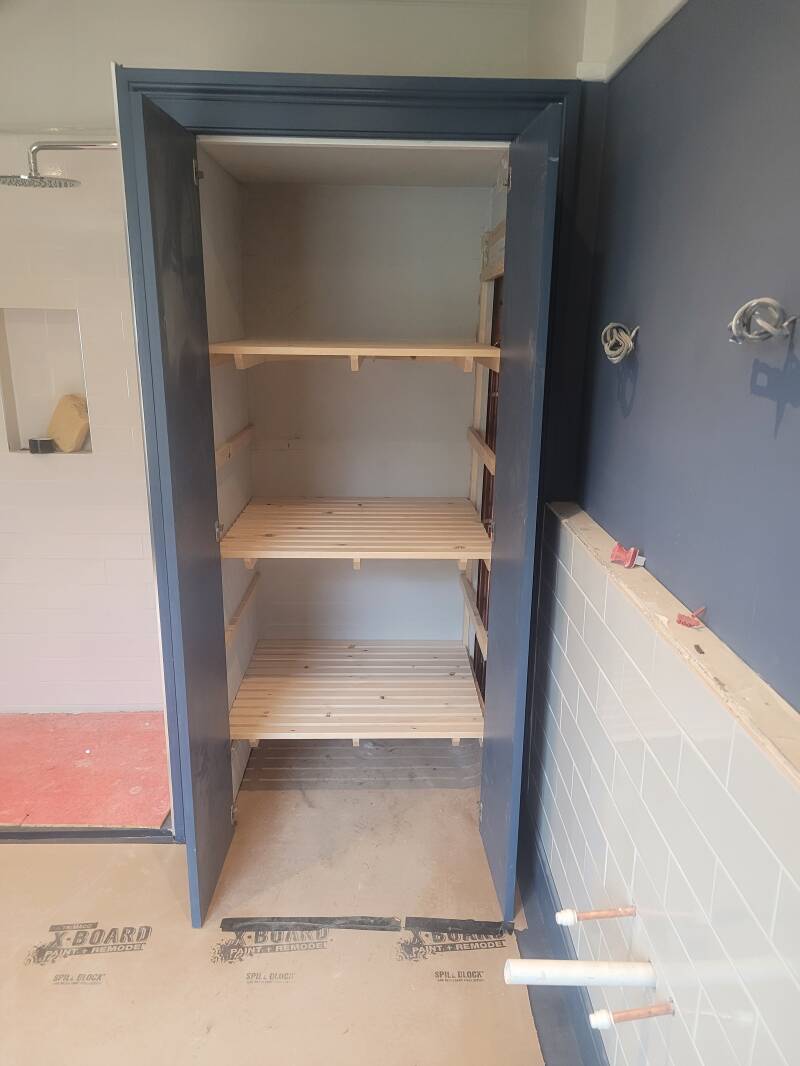 Adjustable slatted shelving inside cupboard 