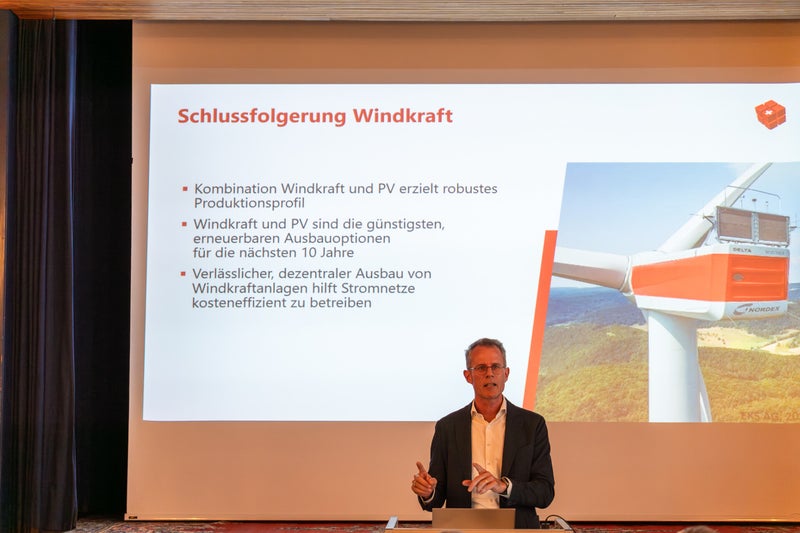 Zu sehen ist Prof. M. Sulzer. Im Hintergrund eine Folie «Schlussfolgerung Windkraft».