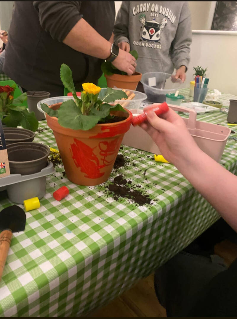 The hands of two people potting plants