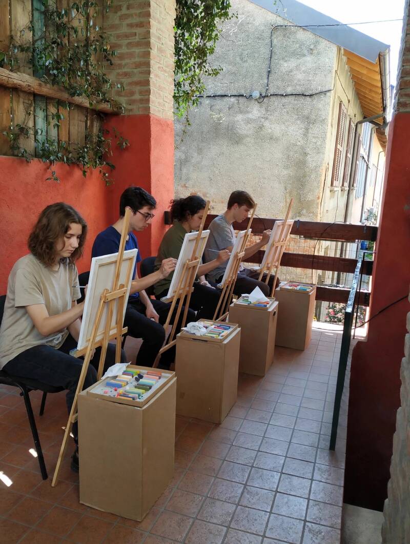 Corso di pittura a pastello all'aperto a Turate - quattro allievi al cavalletto con gessetti pastello morbido su terrazza, scuola d'arte Eleonora Sgura Art