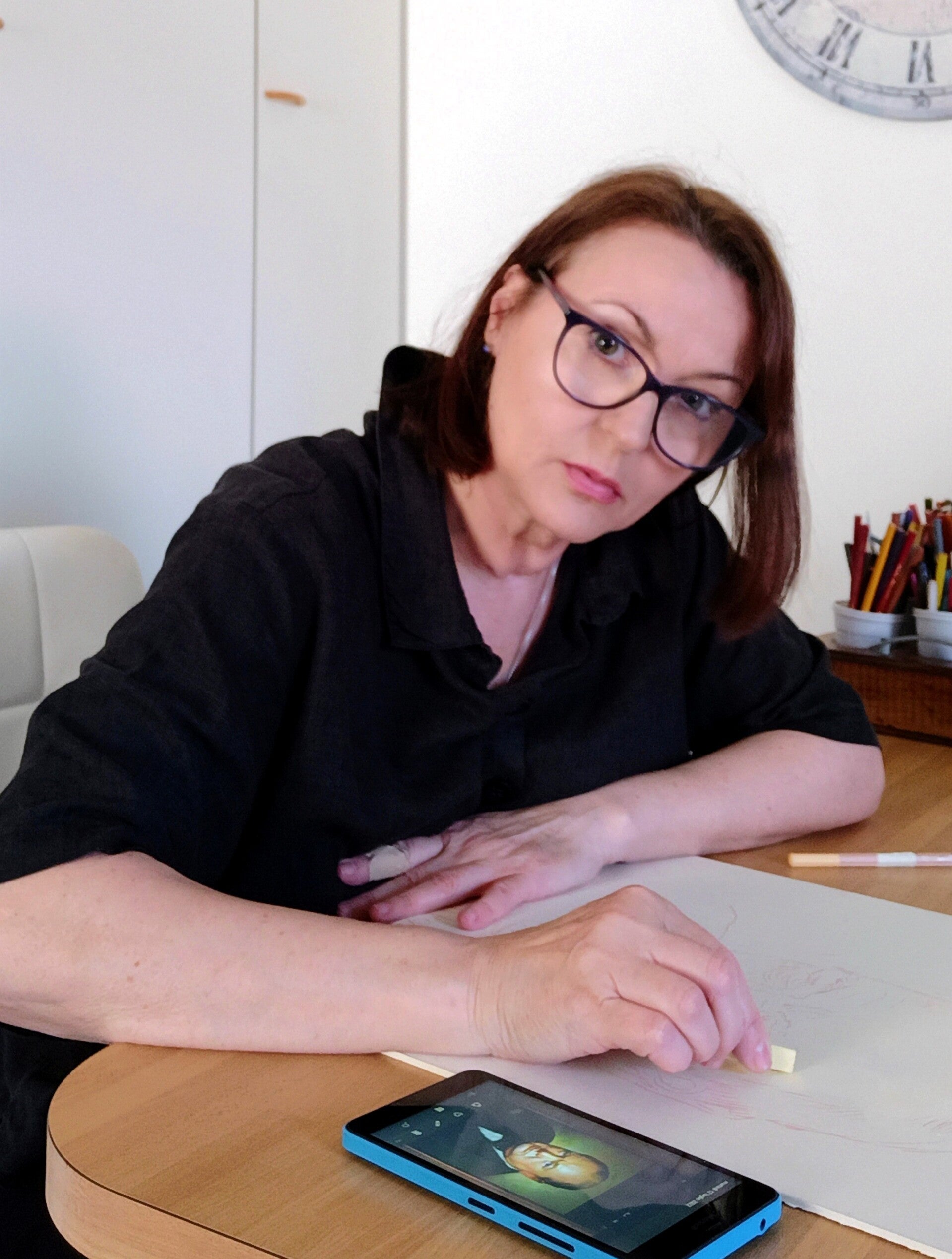 Artista Eleonora Sgura al lavoro in studio su ritratto a pastello morbido con reference fotografica su smartphone, Atelier del Pastello Turate