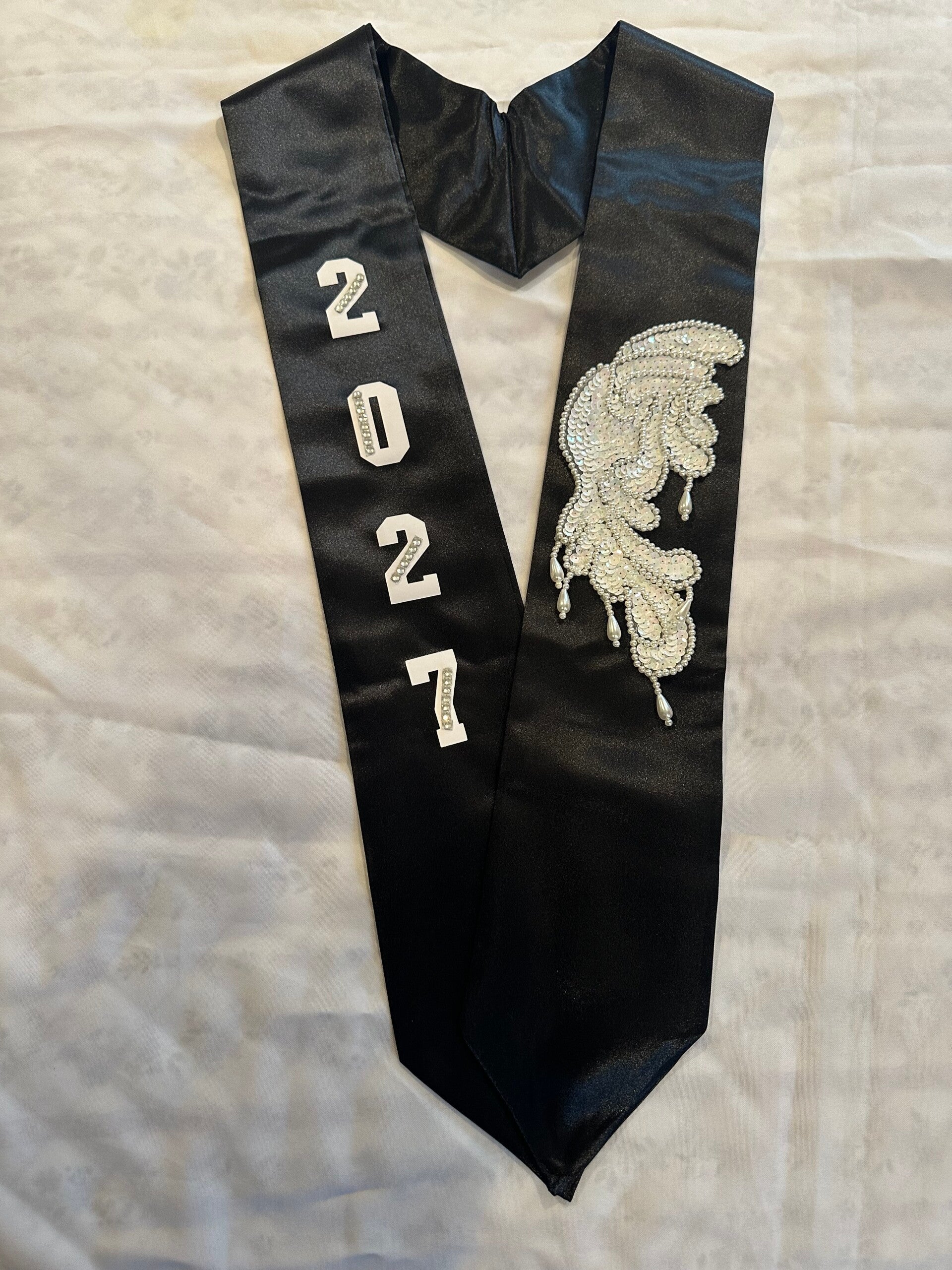 white lettered and winged black stole