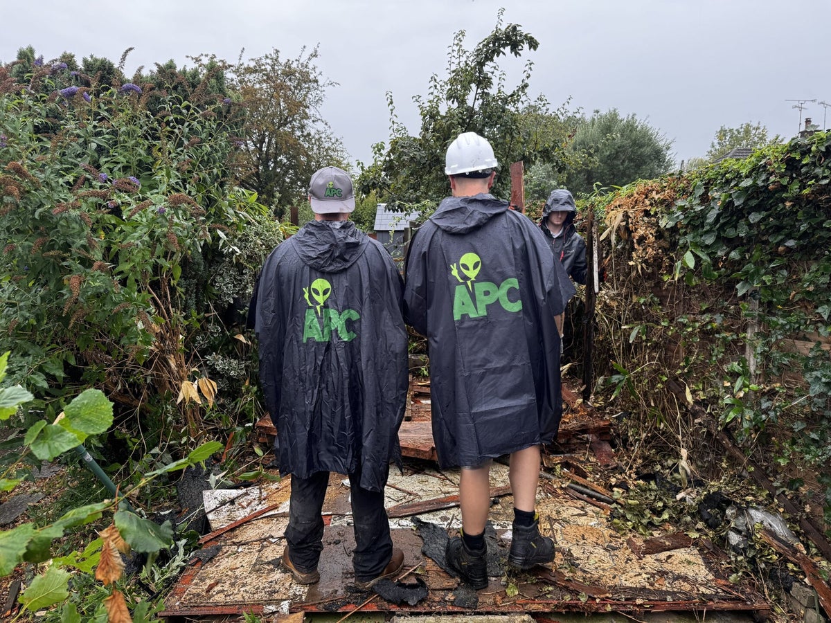 Alien Plant Control team in APC ponchos clearing an overgrown garden