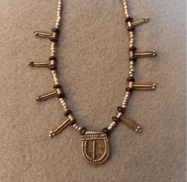 Collier met zilveren kraaltjes en amulet.