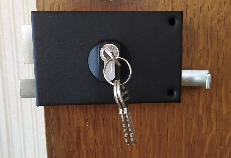 Serrure en applique sur une porte d'entrée en bois avec jeu de clés