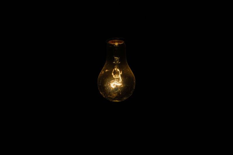 a dimly lit lightbulb on a black background