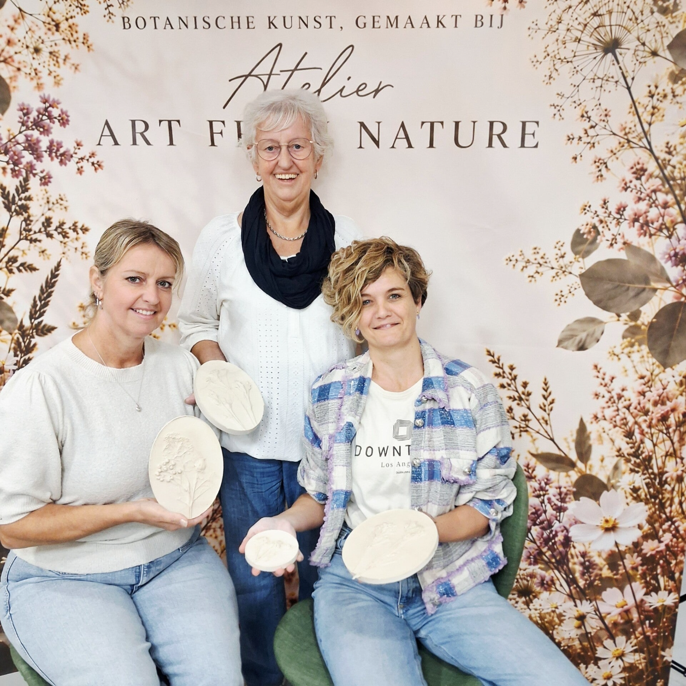 Deelnemers workshop botanische gipstegel maken met bladeren en bloemen