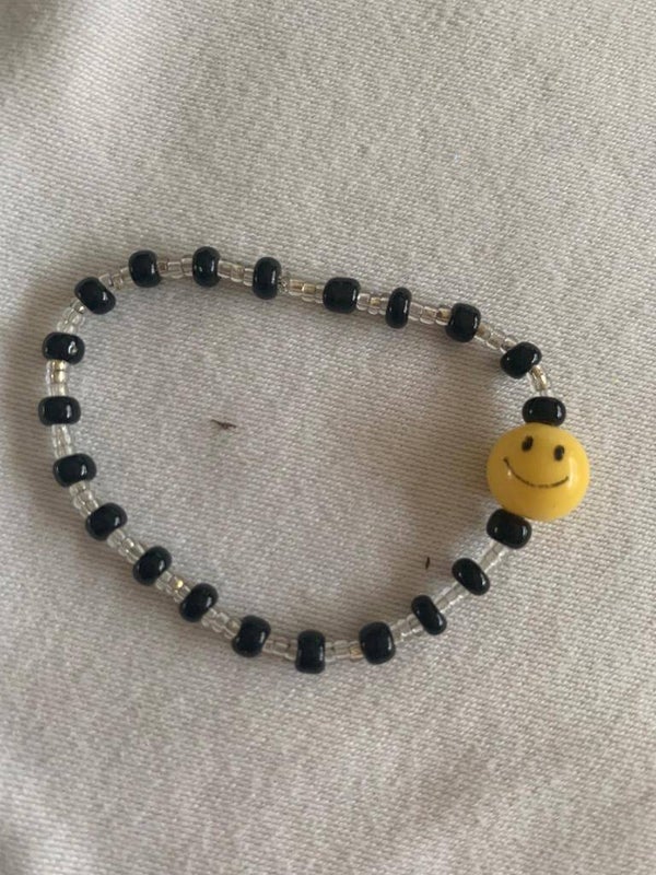 Armband zwart met doorzichtige kralen en gele smiley