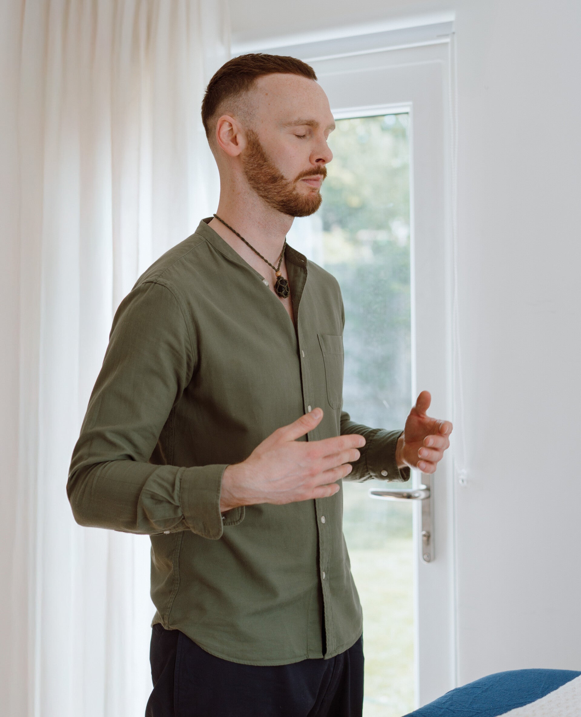 Bjorn at Nordlight Healing standing with his eyes closed and hands held apart, connecting to Reiki and Seichem energy