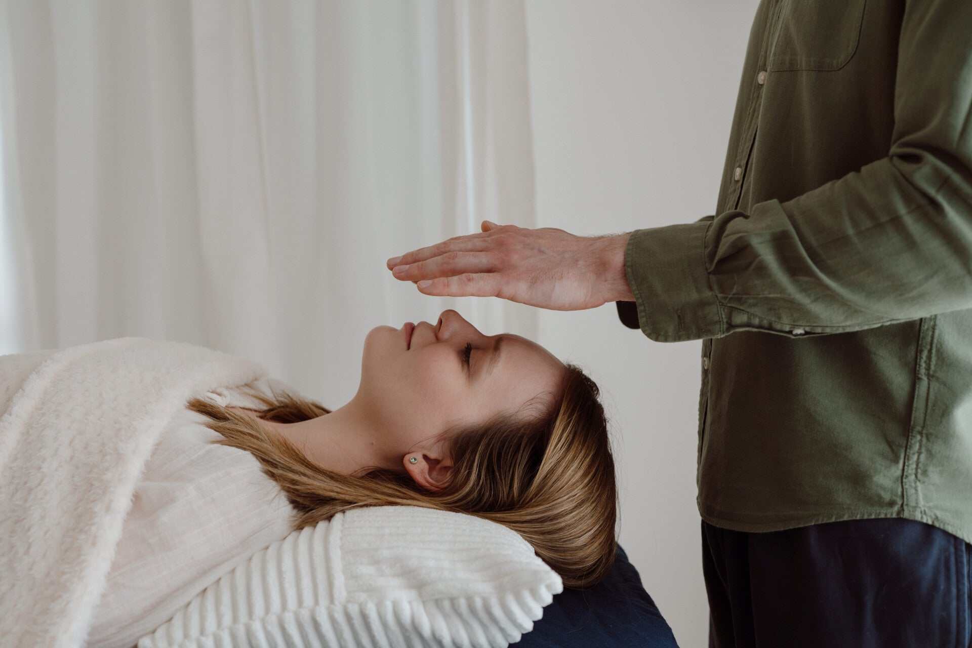 Client receiving Reiki and Seichem energy healing with hands positioned above the head