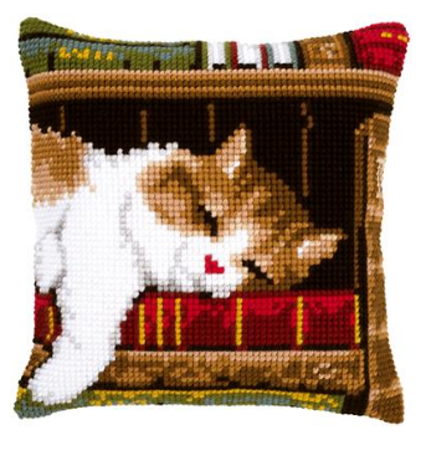 kruissteekkussen slapende kat op boekenrek