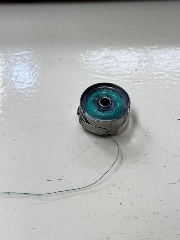 Spoeltje en spoelhuis van een naaimachine