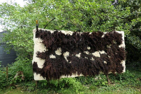 Groot handgevilte wandkleed van donkerbruine Rackawol met spiraalmotief – 90 x 190 cm