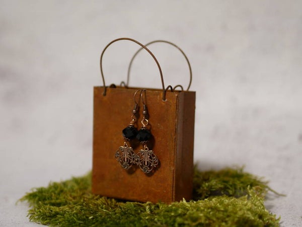 15. Pakketje oorbellen met zwarte facetten en koper hangers