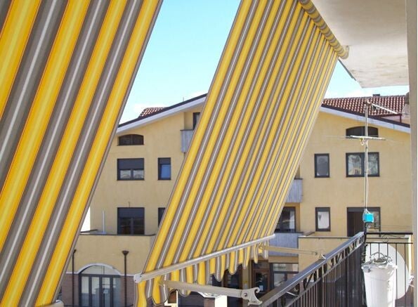 alt="Tenda da sole a bracci installata su balcone a Cosenza"