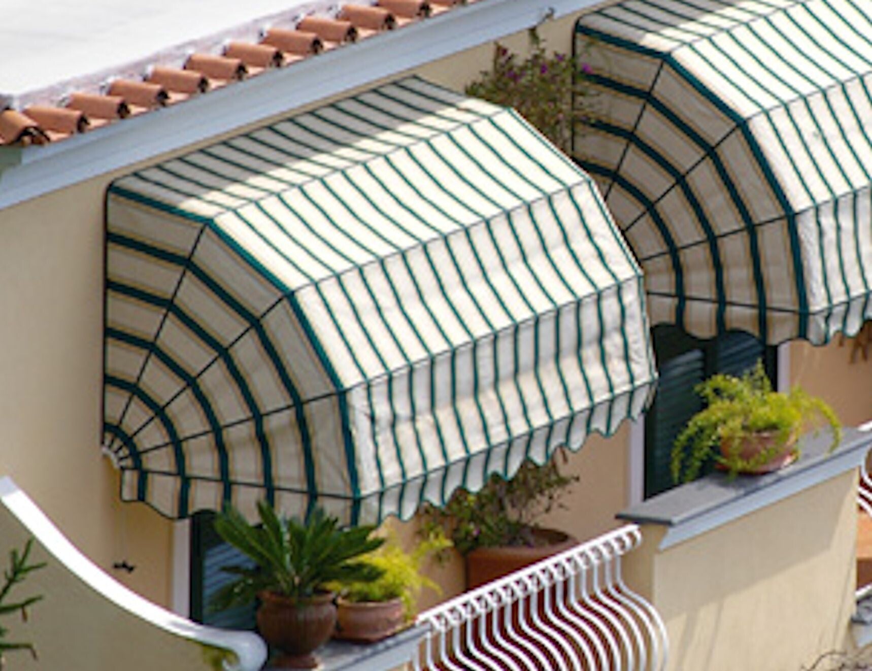 alt="Tenda a cappottina elegante con curve morbide per facciata classica"