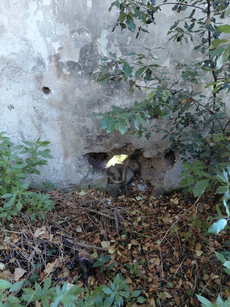 Basamento della muratura con foro passante da cui filtra la luce presso sito storico diruto di Castel di Piero