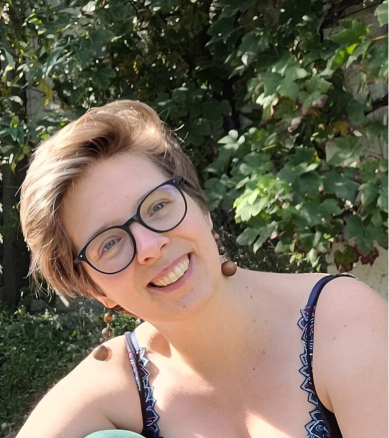 Anja Coulier (schouders en hoofd) kijkt naar de camera en zit in een groene omgeving