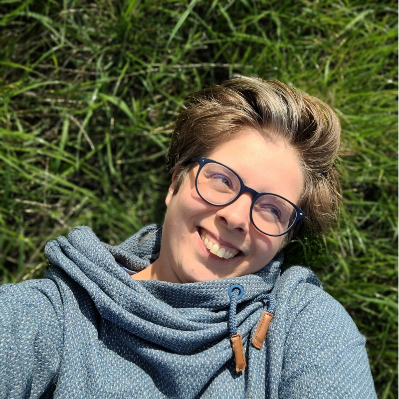 Anja Coulier ligt in het gras en kijkt schuin omhoog