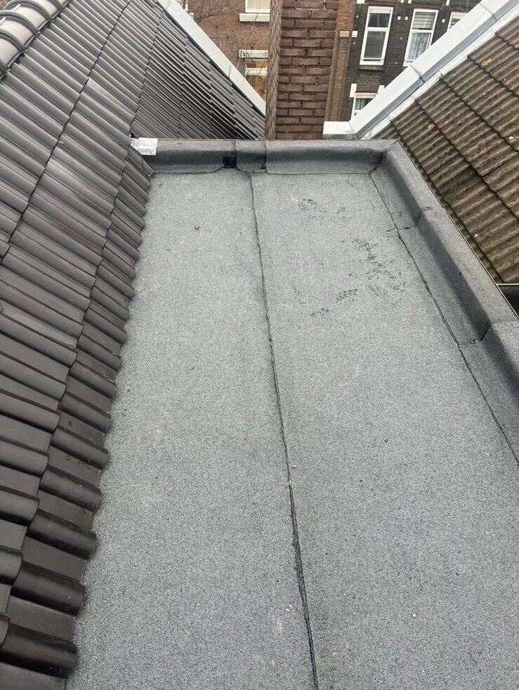 Opgeleverd bitumen dak tussen twee pannendaken