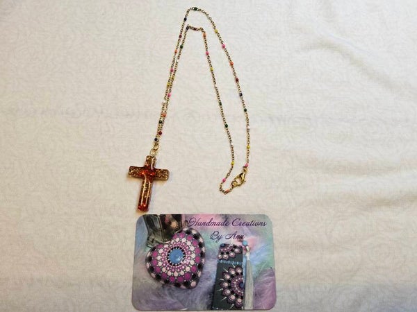 Uniek kruisje in rood en goud aan gouden kettingentje